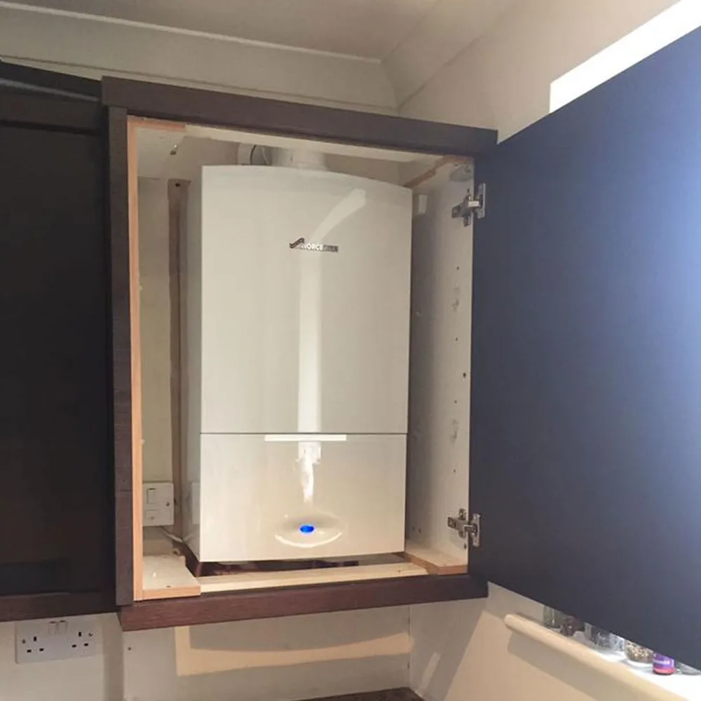 A Worcester Bosch boiler fitted inside a navy kitchen cabinet