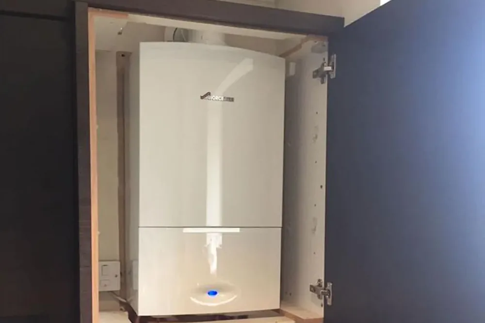 A Worcester Bosch boiler fitted inside a navy kitchen cabinet