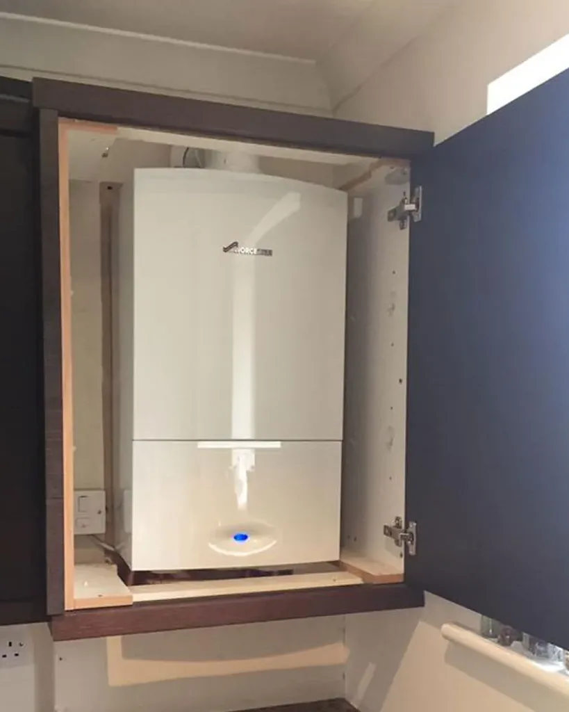 A Worcester Bosch boiler fitted inside a navy kitchen cabinet