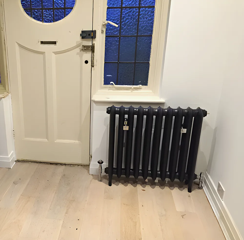 Column radiators fitted either side of a front door with stained glass