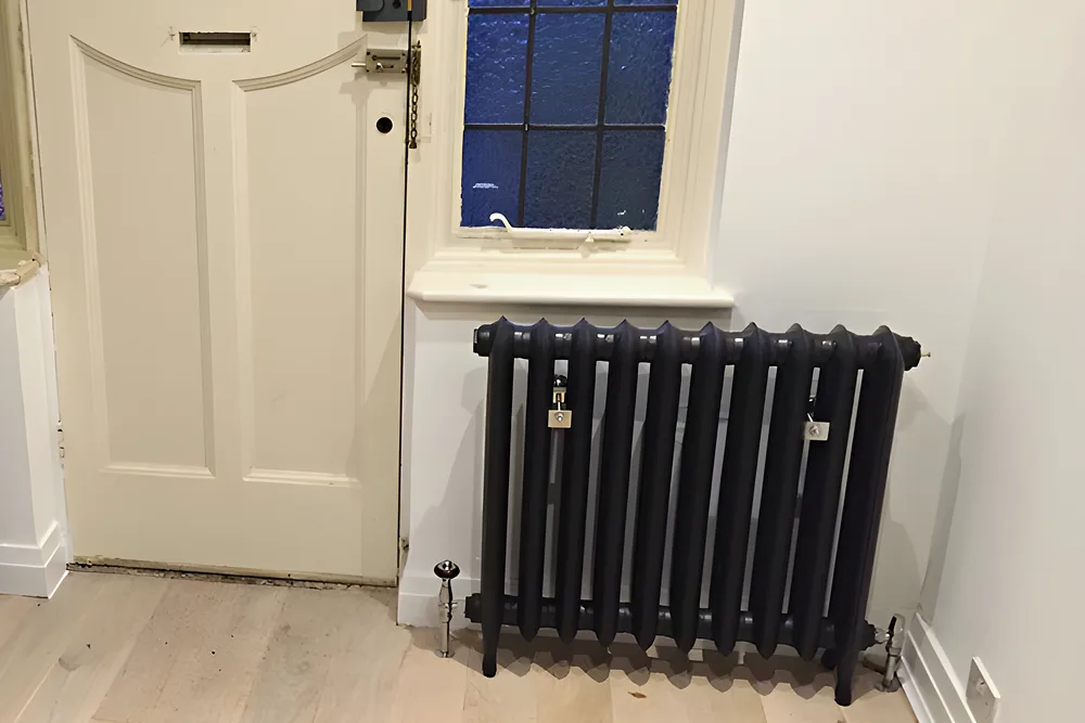 Column radiators fitted either side of a front door with stained glass