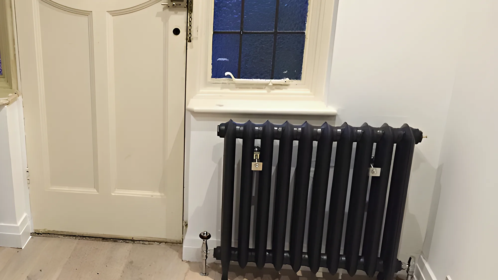 Column radiators fitted either side of a front door with stained glass
