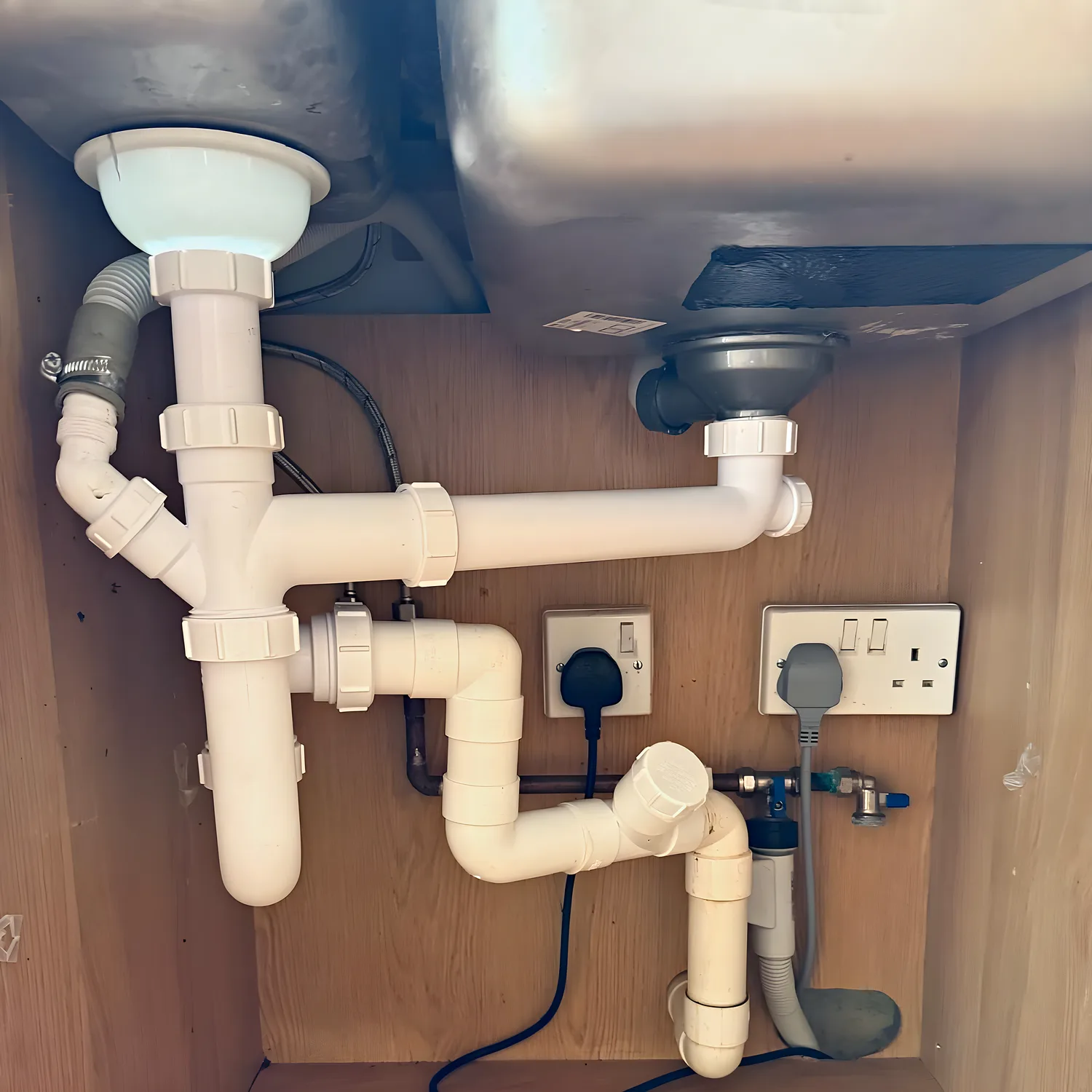 A new double sink trap fitted neatly under a kitchen sink